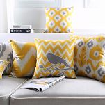 Żółte poduszki dekoracyjne na szarą kanapę, wzory ludowe, etno, Ikat, ptak